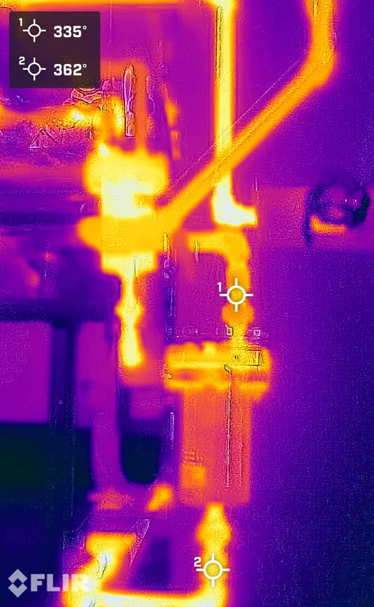Imagem térmica FLIR de um purgador de vapor falhado aberto: tubulação a jusante quente entre 335 e 362°F, mostrando vapor vivo passando pelo purgador